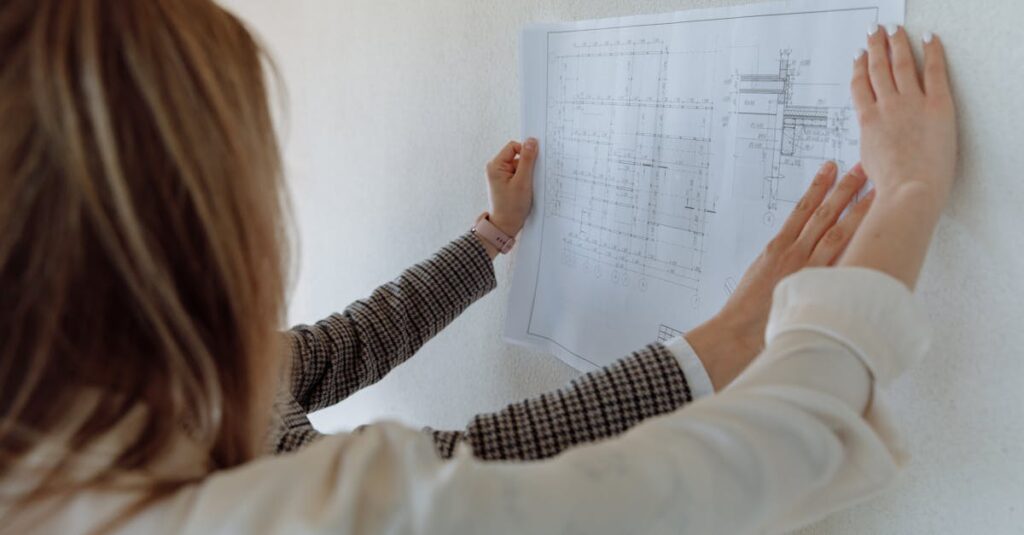 Woman examining a blueprint on the wall in a professional setting.